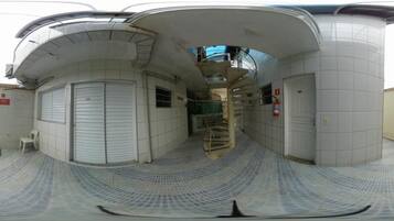 A corridor with closed doors, a spiral staircase, and a small white chair.