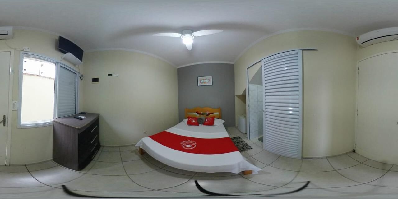 Un dormitorio pequeño con cama, un escritorio, una ventana y un ventilador de techo.