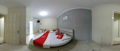 A bedroom with a bed, a desk, and a chair.