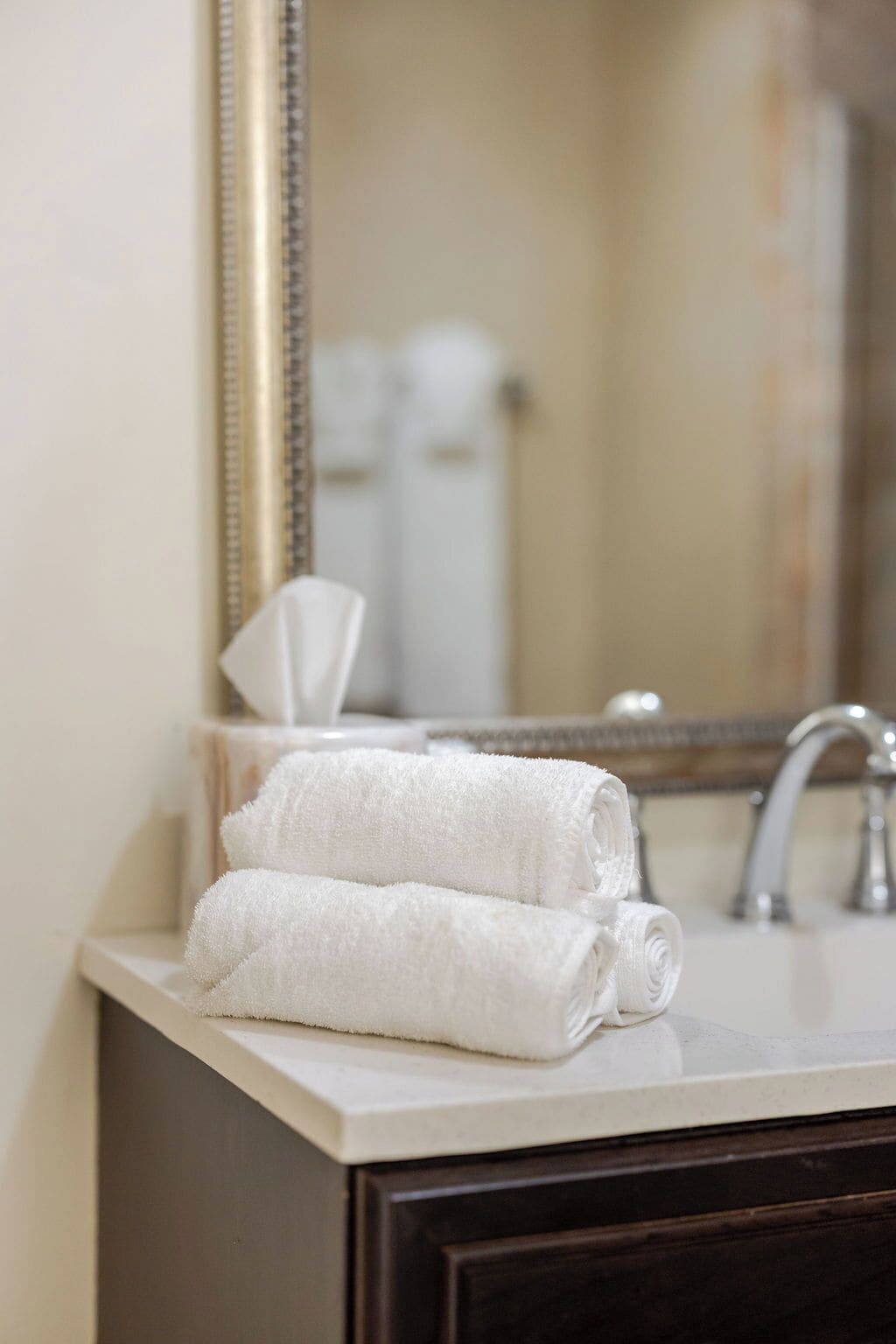 Un baño con lavamanos, espejo y toalla.