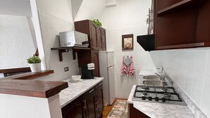 Une cuisine dotée d’un îlot central, d’une cuisinière, d’un four à micro-ondes et d’un réfrigérateur.
