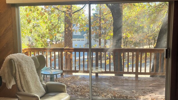 A room with a large sliding glass door leading to an outdoor deck.