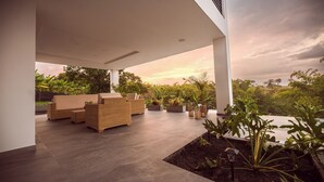 An outdoor patio area with wicker furniture and potted plants.