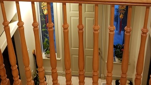 Una escalera de madera con un candelabro colgando sobre ella.