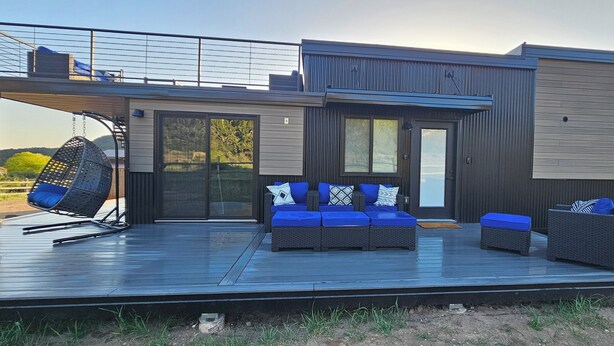 A modern outdoor deck with seating and a hanging chair, overlooking a scenic landscape. - Gray Haven Near Zion 
& Bryce  (Glendale)