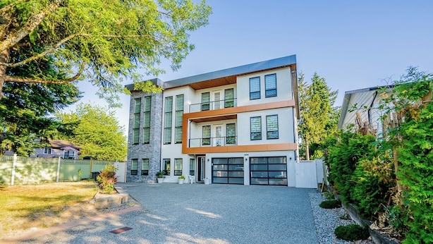 A modern two-story house with a garage, a driveway, and a well-maintained garden. - Newton Suite (Surrey)