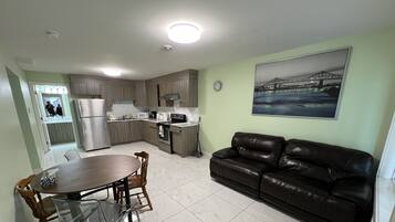 A compact living space with a kitchenette, dining area, and a sofa.
