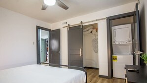 Une chambre comprenant un lit, une armoire, un bureau et une petite kitchenette.