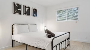 A bedroom with a bed, white walls, and a window with blinds. - Immaculate Apartment in Austin 5 Min to Downtown ATX (Austin)
