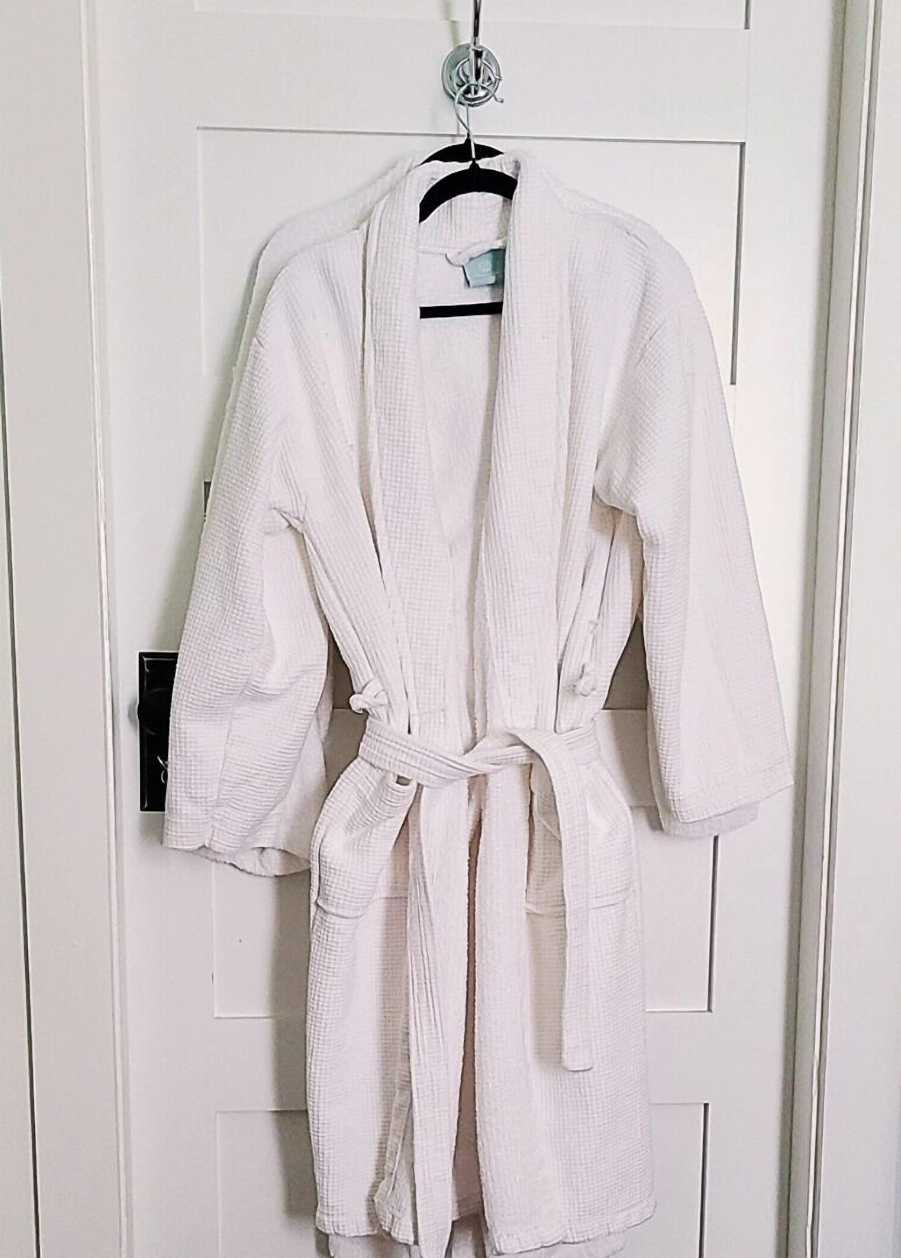 A white robe hanging on a door.