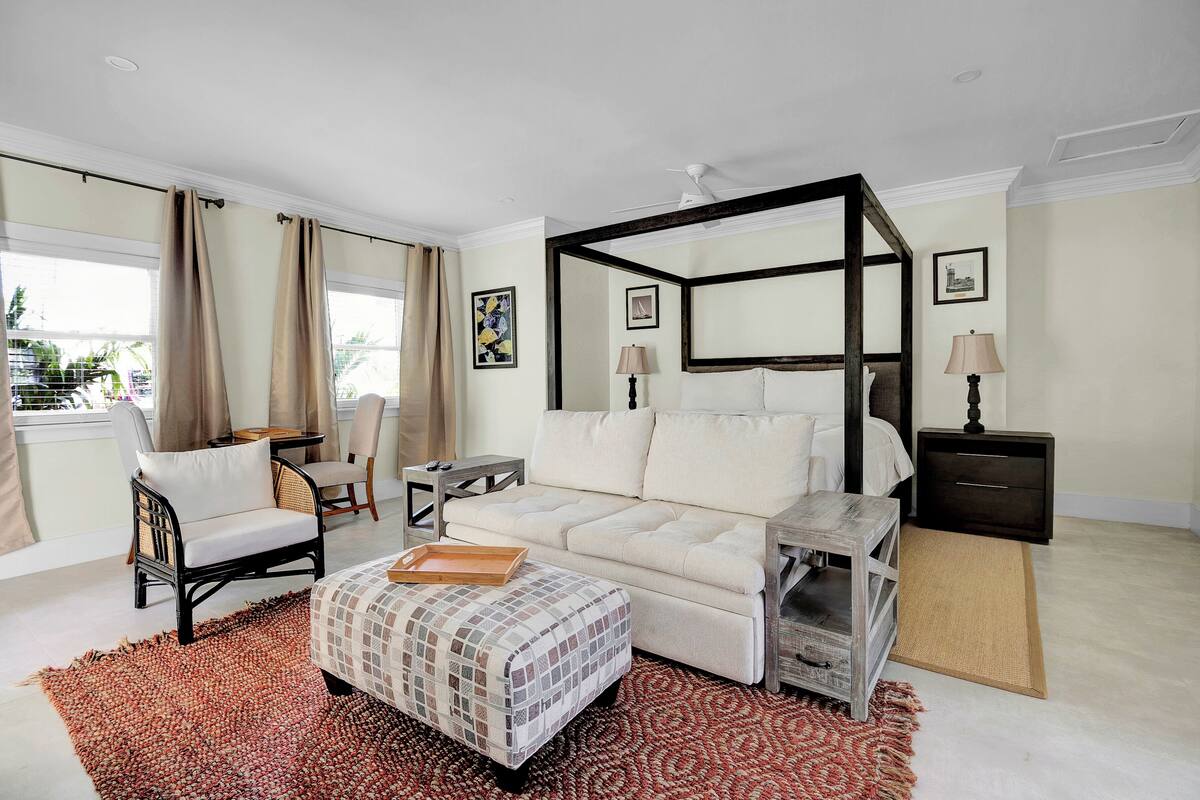 Een moderne hotelkamer met een groot bed, een bank, een eettafel en een stoel.