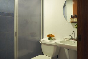A bathroom with a toilet, sink, and shower.