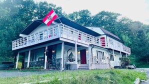 Un immeuble de deux étages doté d’un balcon et d’un drapeau.
