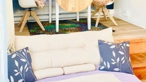Une pièce confortable avec un lit, une petite table, une chaise et un tapis.