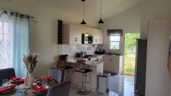 Enjoy cooking in this kitchen with a central island, bar stools, microwave, and gas stove.