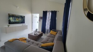 Relax in this stylish living room with a flat-screen TV, comfortable sofa, and a cozy coffee table.