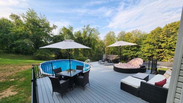 Una terraza con piscina, mobiliario exterior y sombrillas.