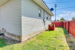 A single-story house with a well-maintained lawn and a red fence.