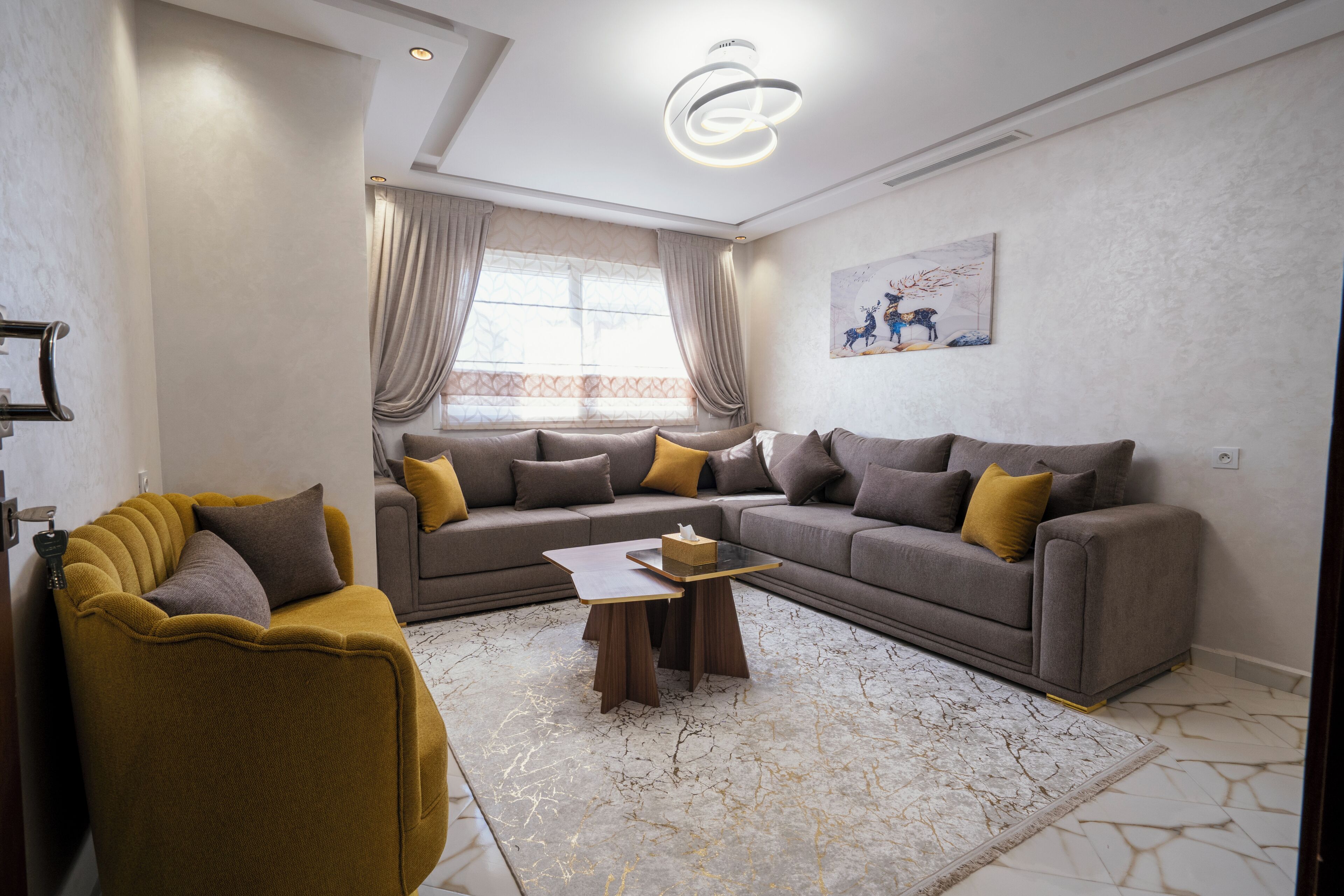 Una sala de estar moderna con un conjunto de sofá, una mesa de centro y un sillón amarillo.