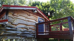 Ein rustikales Holzhaus mit Holztür und kleiner Veranda.