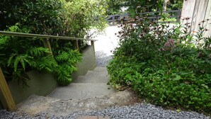 A stone pathway leading up a set of stairs surrounded by lush greenery and a wooden fence. - Vogelsang guesthouse, 5 minute walk to downtown West Jefferson. (West Jefferson)