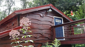 A rustic wooden building with a blue door and a number '437' on the wall.