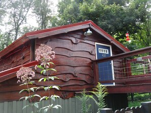 A rustic wooden building with a blue door and a number '437' on the wall.