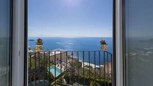 Un balcon avec vue sur la mer et une piscine.