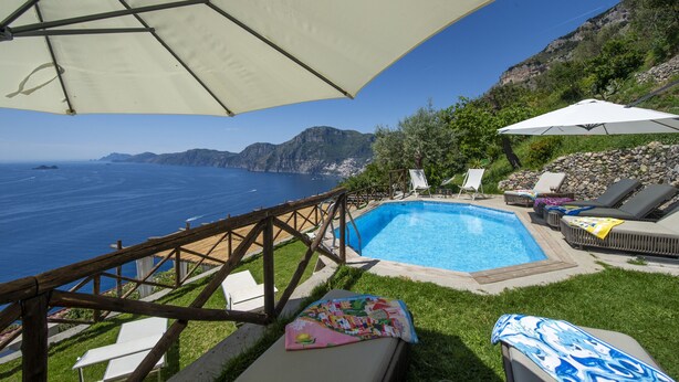 A pool area with a view of the ocean, a wooden deck, and lounge chairs. - Punta di Diamante - 200 Steps to Heaven (Praiano)