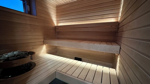 Eine Sauna mit Holzwänden und Fliesenboden.