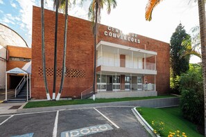Un edificio con un cartel que dice 'CENTRO DE CONVÊNÇÃO' y un estacionamiento con espacios marcados con la letra 'P'.