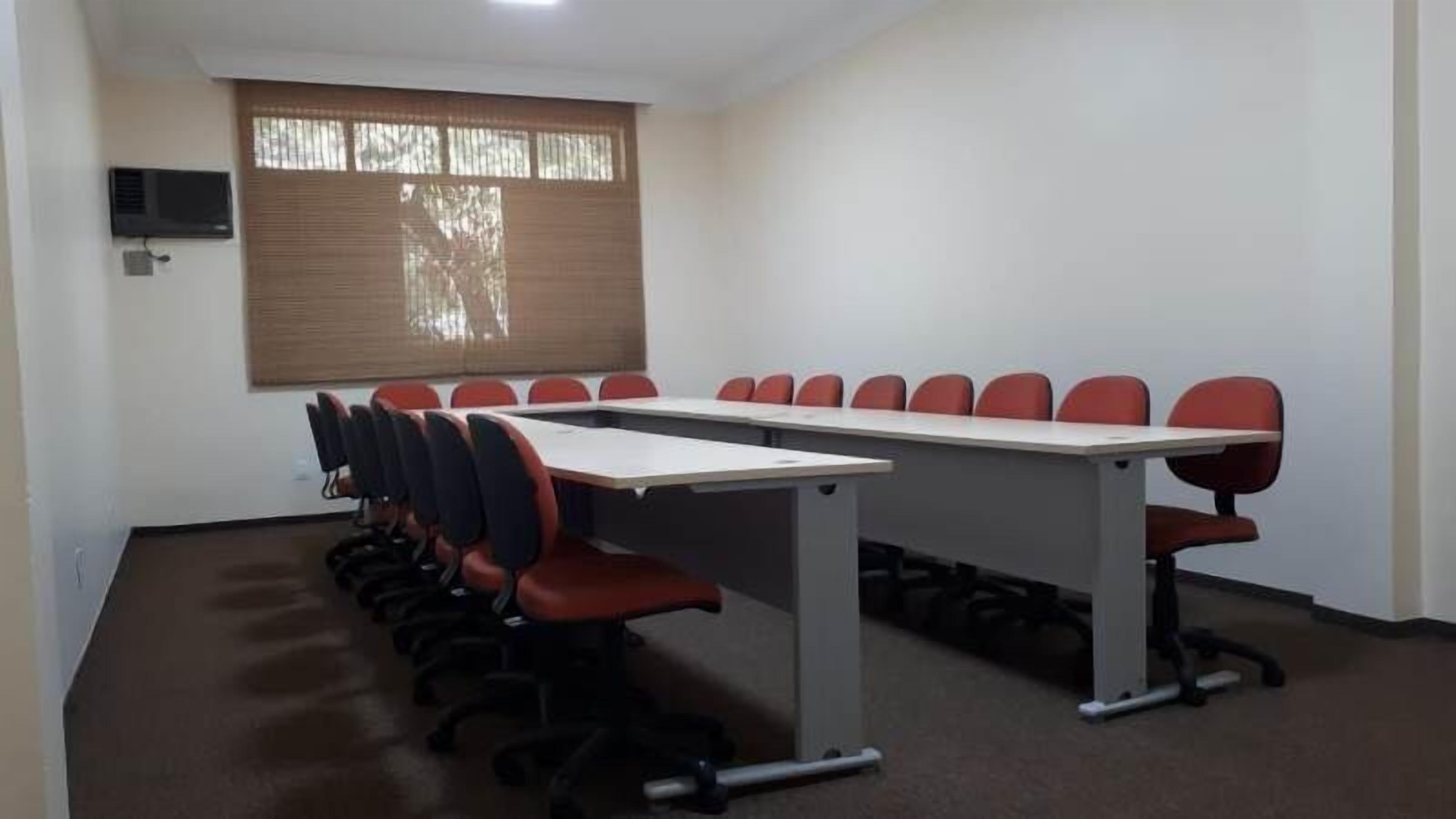Uma sala de conferência com uma mesa comprida e várias cadeiras.