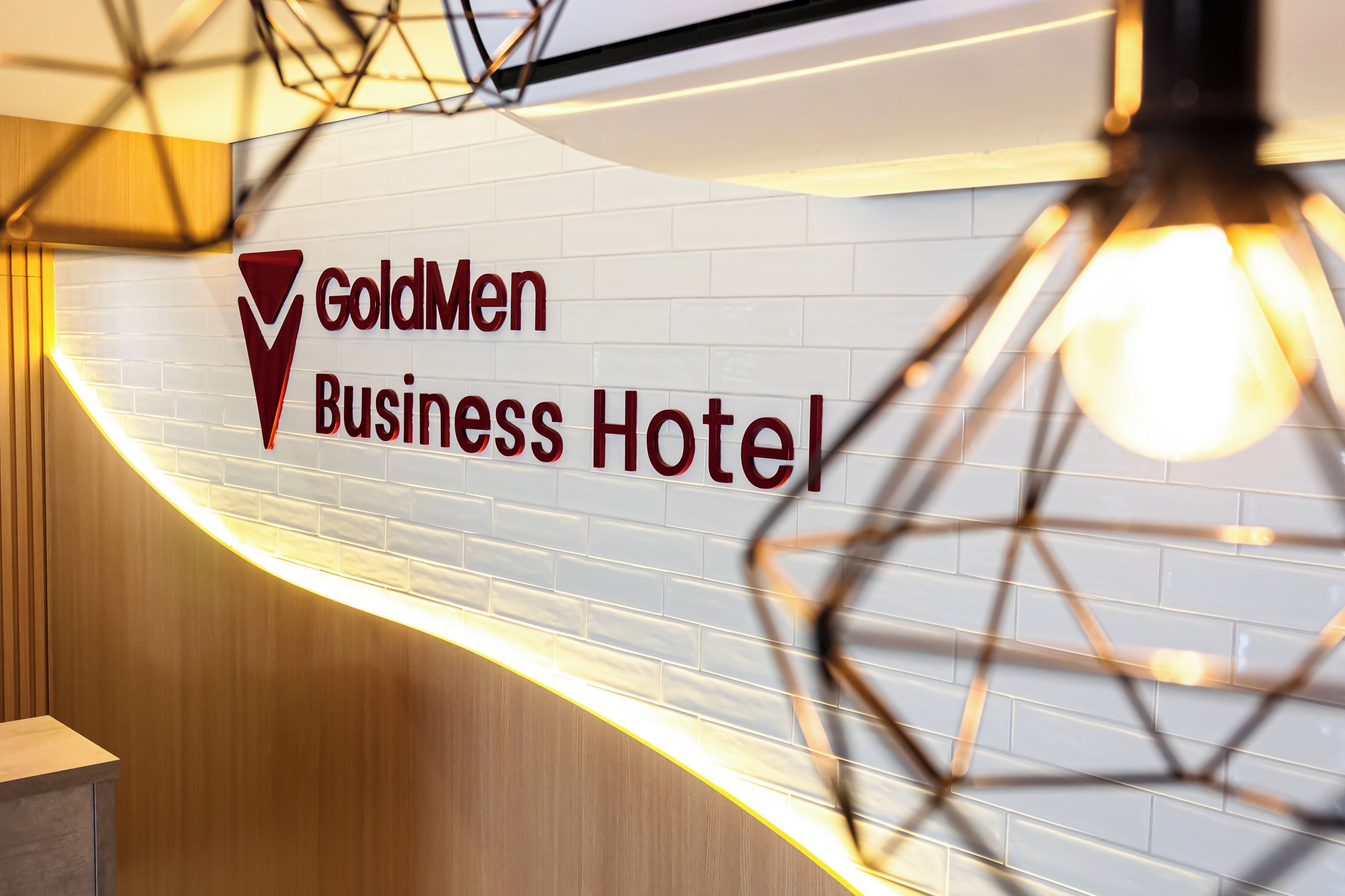 A sign for the GoldMen Business Hotel with a modern design.