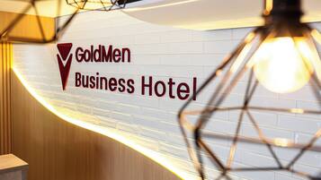 A sign for the GoldMen Business Hotel with a modern design.