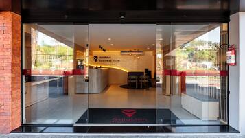 La entrada del Hotel GoldMen Business, con una recepción, zona de estar y vistas al exterior.