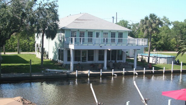 A waterfront house with a balcony, a dock, and a swimming pool. - Camp Gator #2 (Barataria)