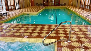 An indoor swimming pool with a checkered floor pattern, a central lane divider, and a lifeguard chair. - Loon Mountain Retreat at Lincoln NH (Lincoln)
