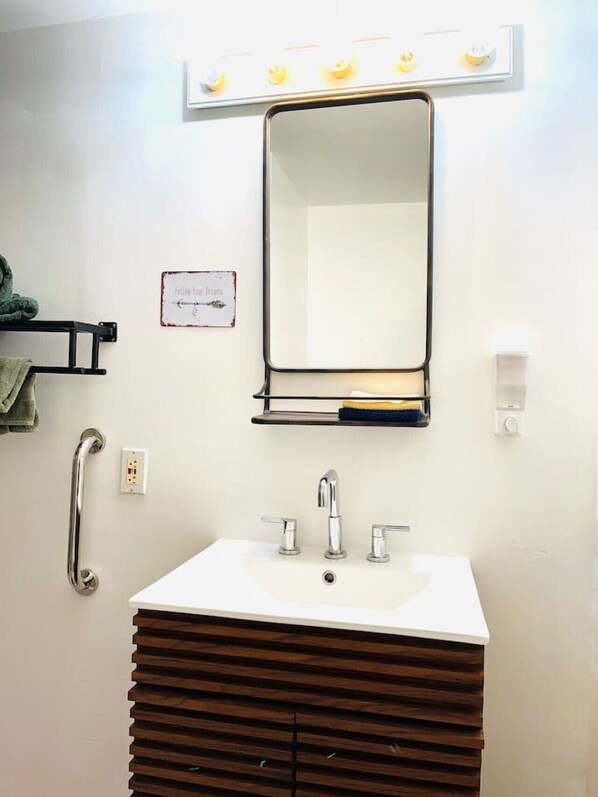 A bathroom with a white sink, a mirror, a towel rack, a handrail, and a sign that says "Follow Your Dreams". - Catskills The Bohemian Dream (Shandaken)