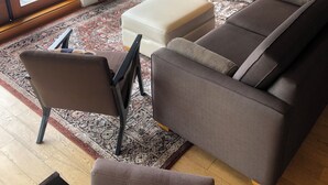 A living room with a sectional sofa, a fireplace, a TV, and a large window. - Mariner's Loft Salt Spring Island - 2BDRM - Unit 201 (Salt Spring Island)