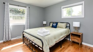 A bedroom with a bed, bedside tables, and a window. - TDJ Getaway<>4BR Home w/game room (South Bend)