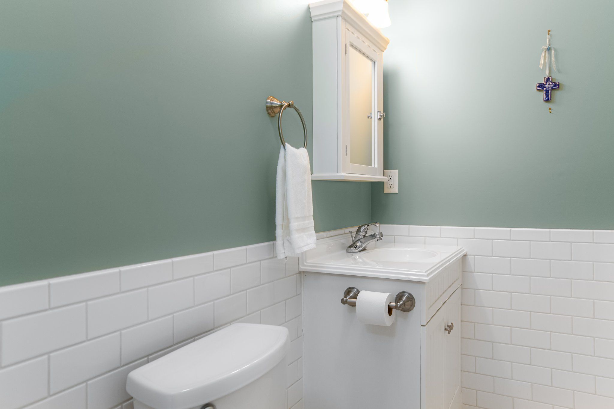 Ein Badezimmer mit Toilette, Waschbecken und Spiegel sowie einem Handtuchhalter.