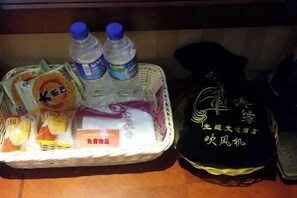 Un panier contenant des collations, des bouteilles d’eau et un sac noir orné de caractères chinois.