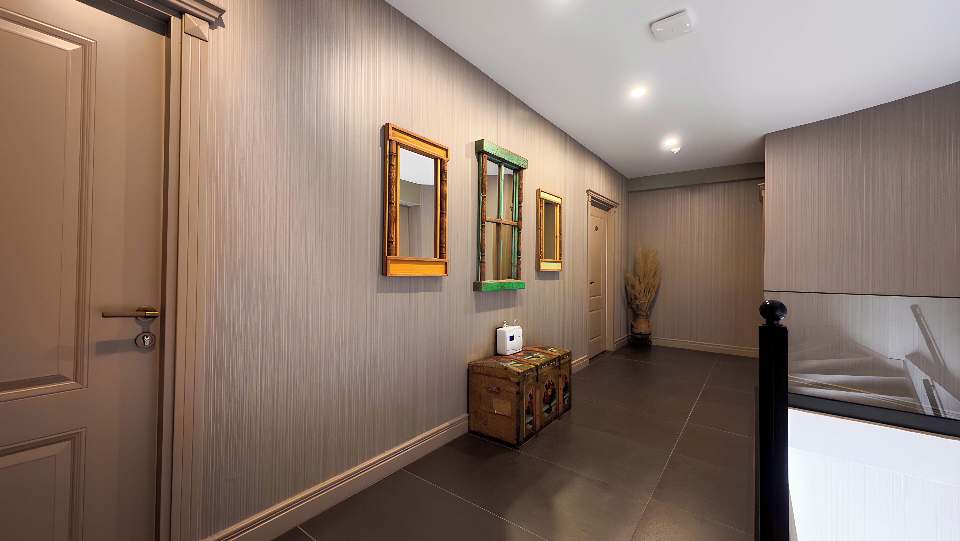 A hallway with vertical paneling, a wooden bench with a suitcase, and a wall-mounted mirror.