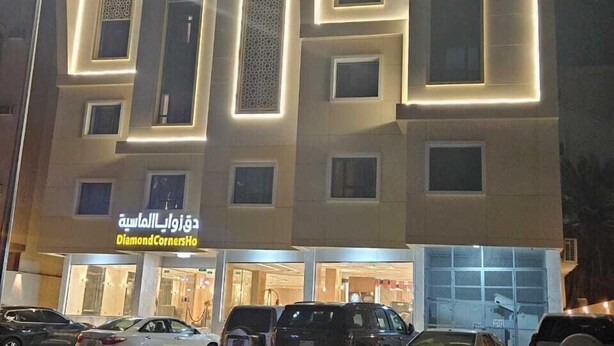 A modern building with multiple floors, featuring a prominent sign for 'DiamondCornersHo'. - Diamond corners Hotel (Madinah)