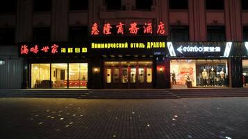 A hotel facade with signage in multiple languages, including English and Chinese.