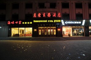 A hotel facade with signage in multiple languages, including English and Chinese. - Huilong Business Hotel (Fuyuan)