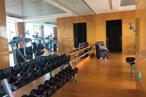 A gym with weightlifting equipment, benches, and a mirrored wall. - Joylake Hotel (Jianhu)