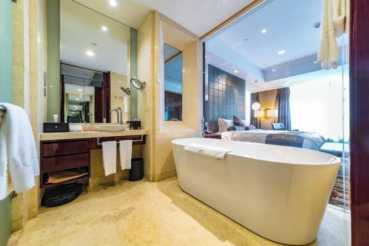 Ein modernes Badezimmer mit einer großzügigen Badewanne, einem Waschtisch inklusive Spiegel und einer Duschkabine.
