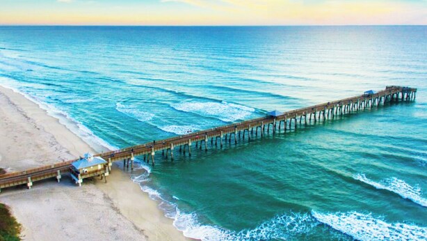A pier extending into the ocean with a beach on one side. - Luxury, Private Suite in cool Palm Beach Gardens with WiFi, AC (Palm Beach Gardens)
