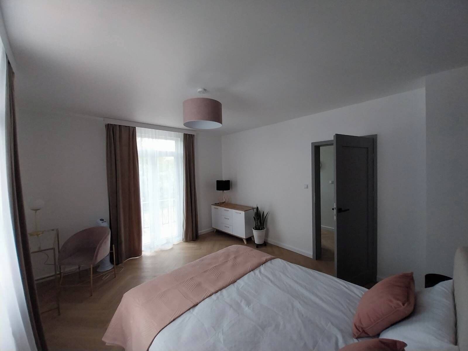 Ein modernes Schlafzimmer mit Bett, Schreibtisch, Stuhl und Kleiderschrank.
